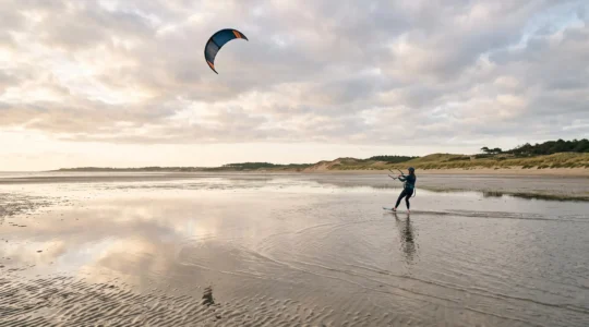 Kitesurfeur débutant naviguant sur une vaste étendue de sable à marée basse sur la côte de Loire-Atlantique
