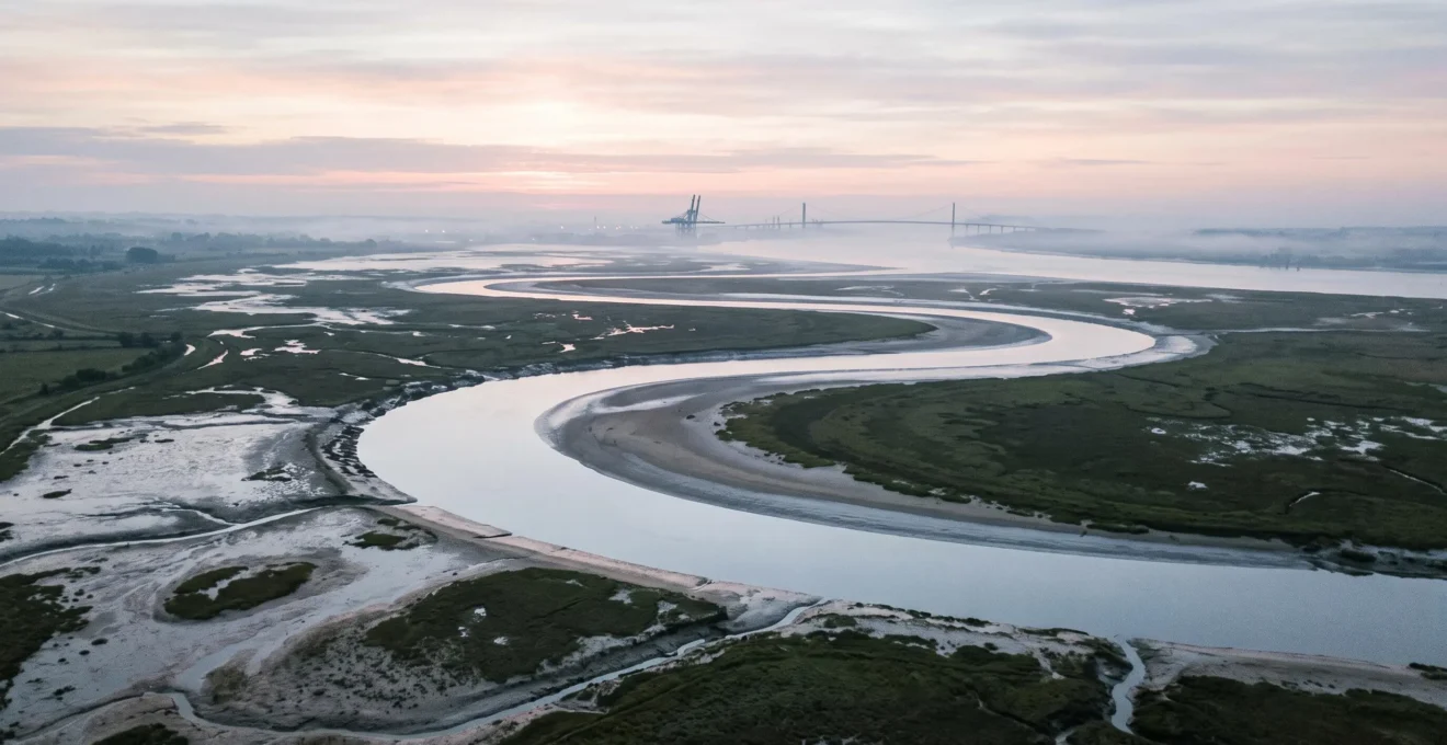 Vue panoramique de l'estuaire de la Loire entre Nantes et Saint-Nazaire au lever du jour, avec vasières et méandres du fleuve